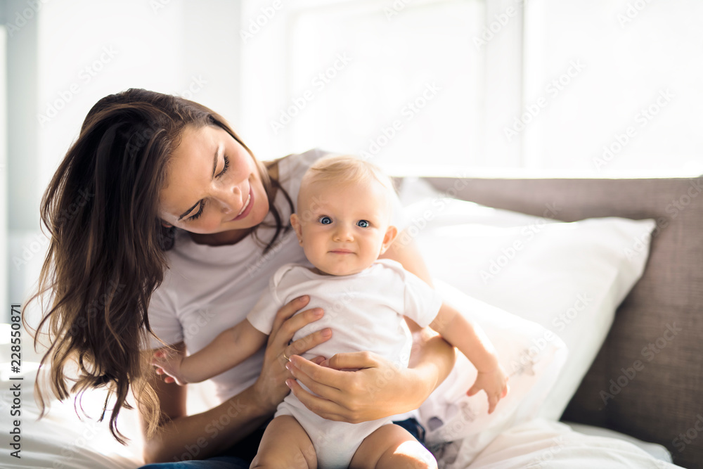mother with baby on bed having good time mother with baby on bed having good time