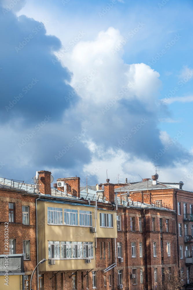 Old brick buildings and the sun reflecting on them with blue sky and clouds