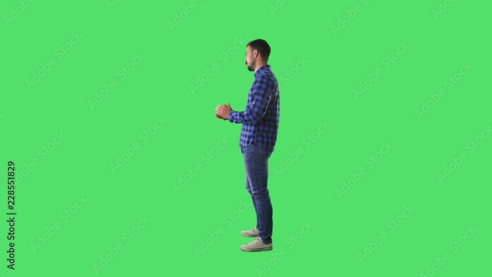 Profile view of young man having conversation talking and arguing looking away at copyspace. Full body isolated on green screen background. Profile view of young man having conversation talking and arguing looking away at copyspace. Full body isolated on green screen background.