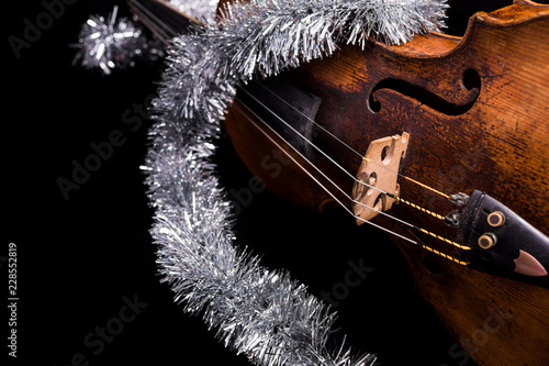 A viola or violin with a christmas ornament on a black background