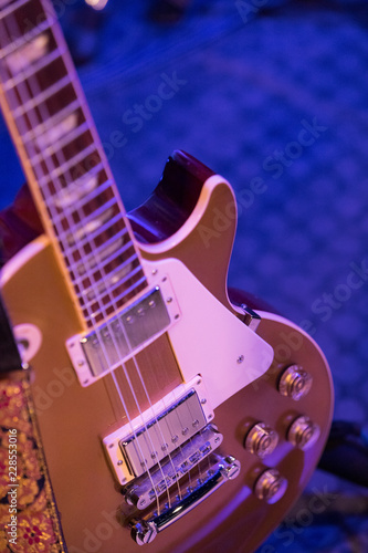 Part of a six string guitar in a club setting