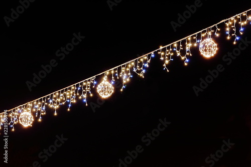 Luminous Christmas gerland on a dark background. Copy space. Christmas, New Year's background. Glowing garland on black sky background photo