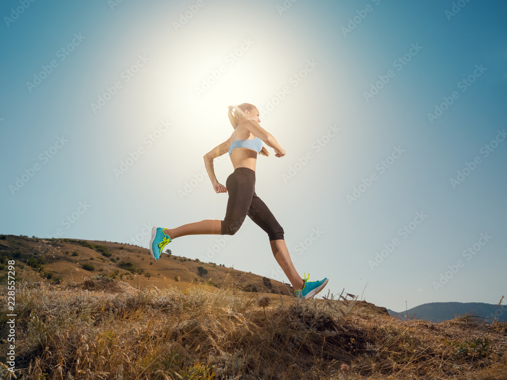 Woman running. Young girl runner jogging on a mountain trail in