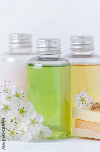 natural cosmetic bottles and soap bar with fresh flowers