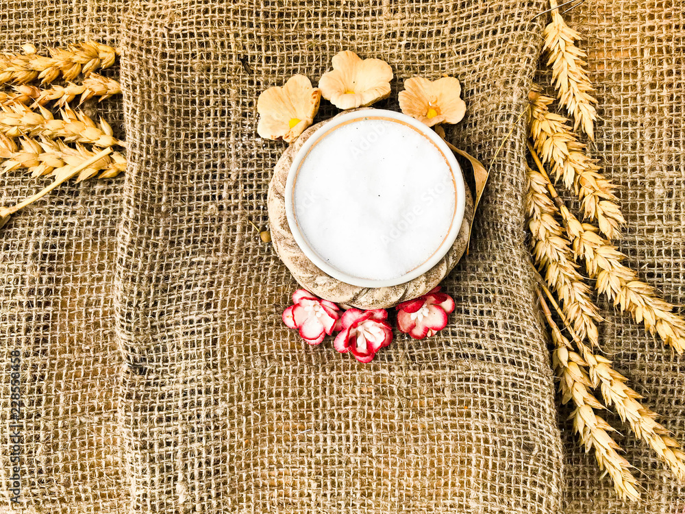 Wheat spikelets of straw and salt shaker with salt on an old brown rough canvas, tablecloth. Slavic symbol of welcome bread and salt. The background. Texture Wheat spikelets of straw and salt shaker with salt on an old brown rough canvas, tablecloth. Slavic symbol of welcome bread and salt. The background. Texture