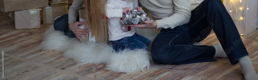 mother with a small child near the New Year tree. beside are gifts and a fireplace mother with a small child near the New Year tree. beside are gifts and a fireplace