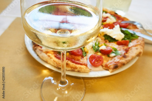 Glass of white wine and pizza Italy