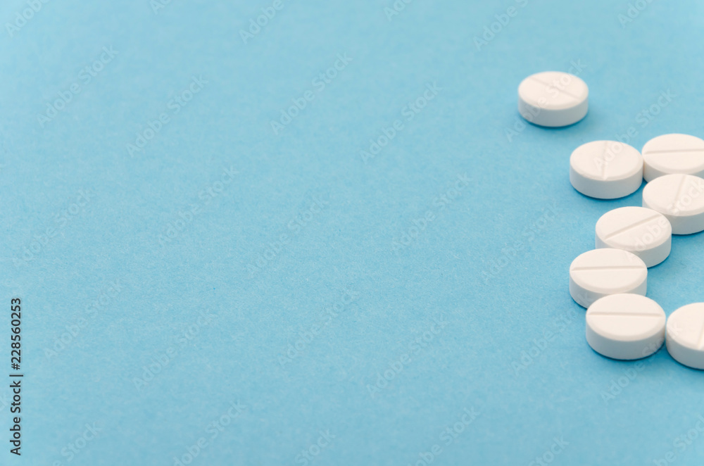 Close-up of handful of pills on blue background Close-up of handful of pills on blue background