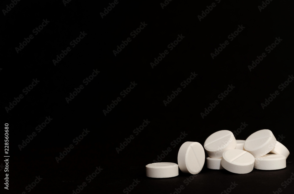 A lot of tablets on the right on a black background A lot of tablets on the right on a black background