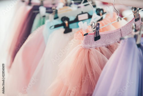 Fotografie Clothing for a little girl on a clothes rack in a wardrobe