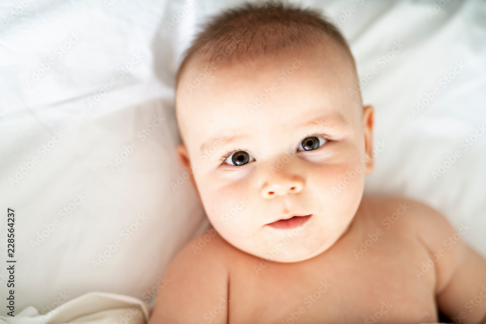 happy cute baby lying on white sheet happy cute baby lying on white sheet