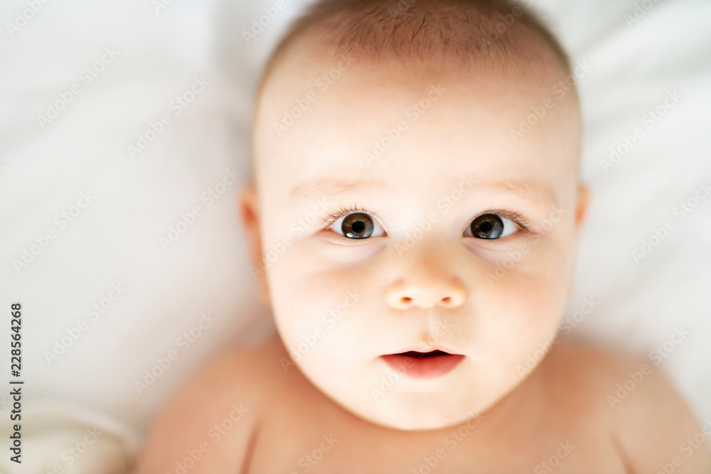happy cute baby lying on white sheet happy cute baby lying on white sheet