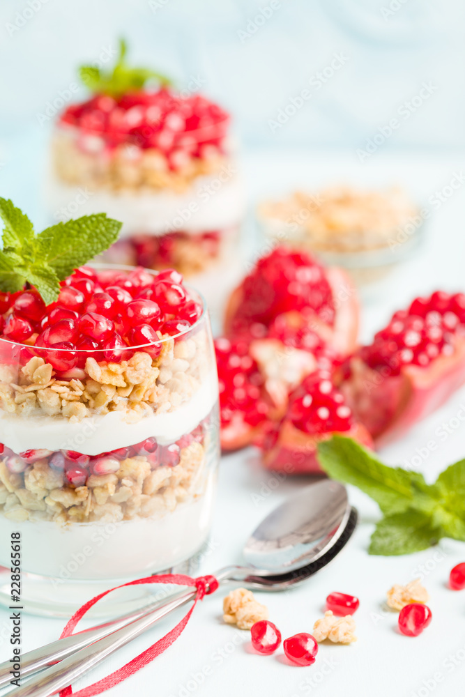 Pomegranate parfait - sweet organic layered dessert with granola flakes, yogurt and red ripe fruit seeds. Pomegranate parfait - sweet organic layered dessert with granola flakes, yogurt and red ripe fruit seeds.