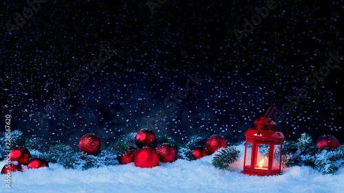 Laterne mit Weihnachtskugeln und Tannenzweig vor dunklem Hinterdrund mit Schnee © Karin & Uwe Annas