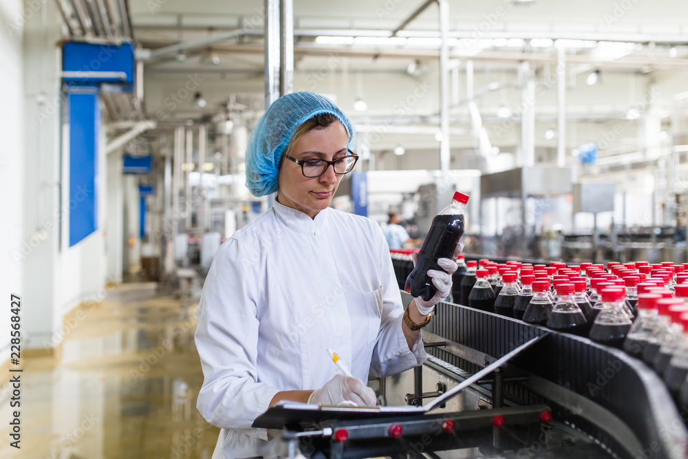 Woman Quality Control Serious middle age woman quality control worker checking robotic line ...