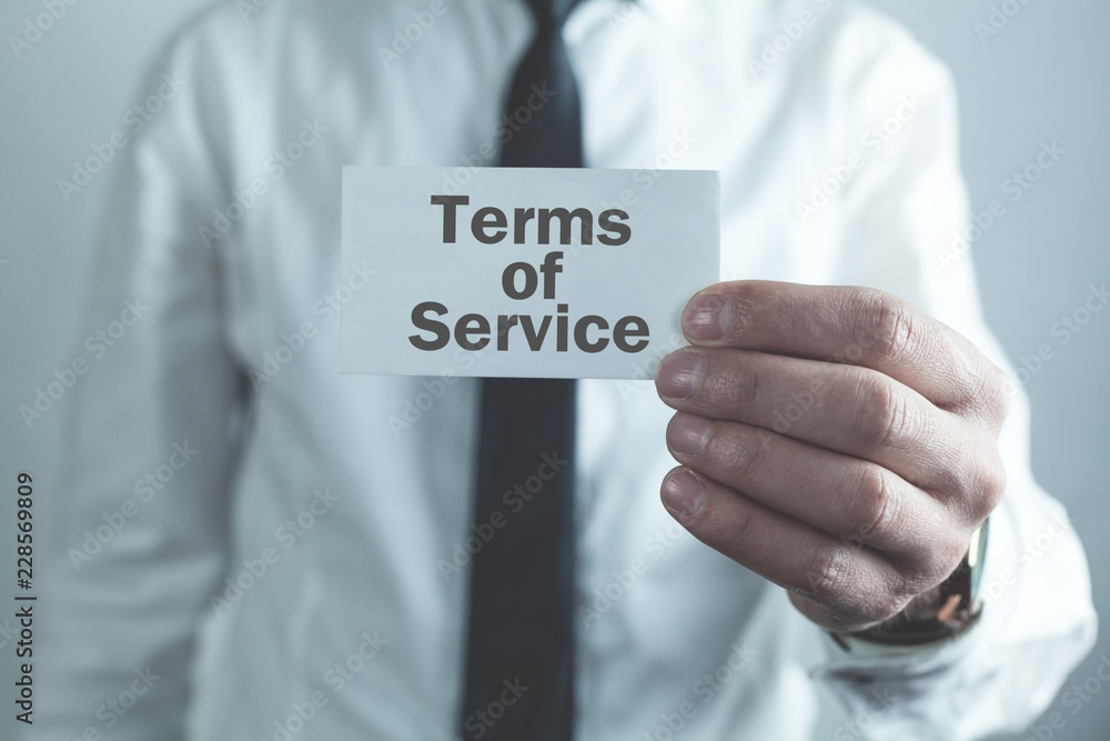 Businessman showing word Terms of Service on business card. Businessman showing word Terms of Service on business card.