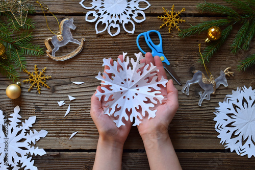 Making paper snowflakes with your own hands. Children's DIY. Merry Christmas and New Year concept.