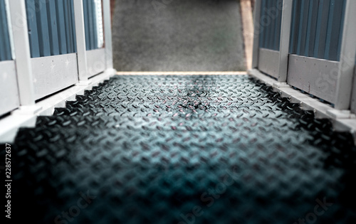Some dangerous wet metal steps with a white wooden railing