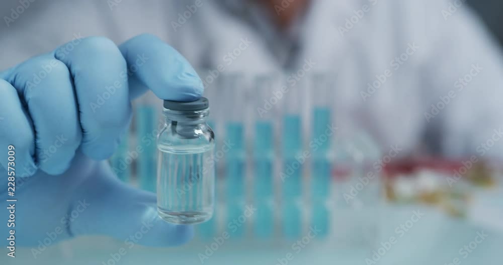 Portrait of a scientist holding and showing a test tube in a laboratory. Concept: chemistry, Laboratory, science. Shot on RED 8K Portrait of a scientist holding and showing a test tube in a laboratory. Concept: chemistry, Laboratory, science. Shot on RED 8K