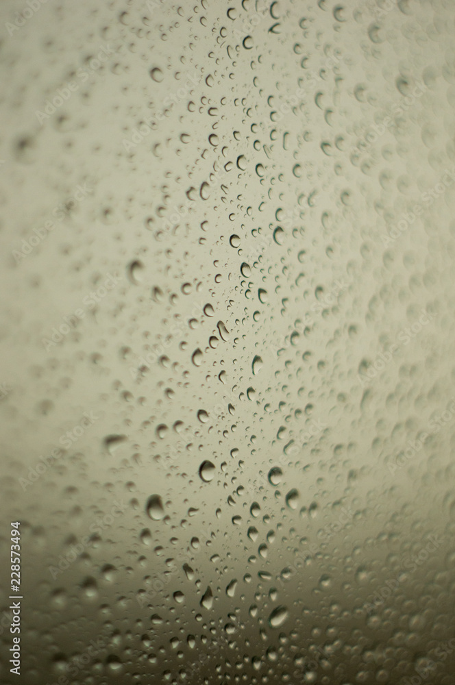 raindrops on window glass on background of cloudy sky raindrops on window glass on background of cloudy sky