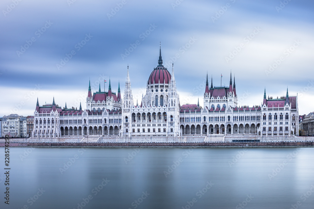 Obraz premium Front view to the Hungarian Parliament on a cloudy day in Budapest, Hungary
