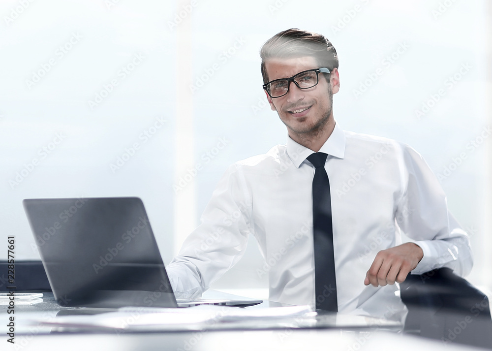 smiling young businessman sitting in a spacious office