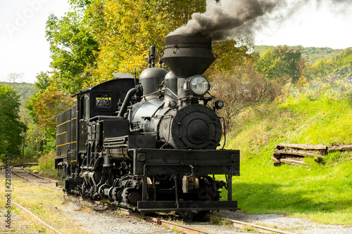 Old steam locomotive sitting on the railroad tracks in color
