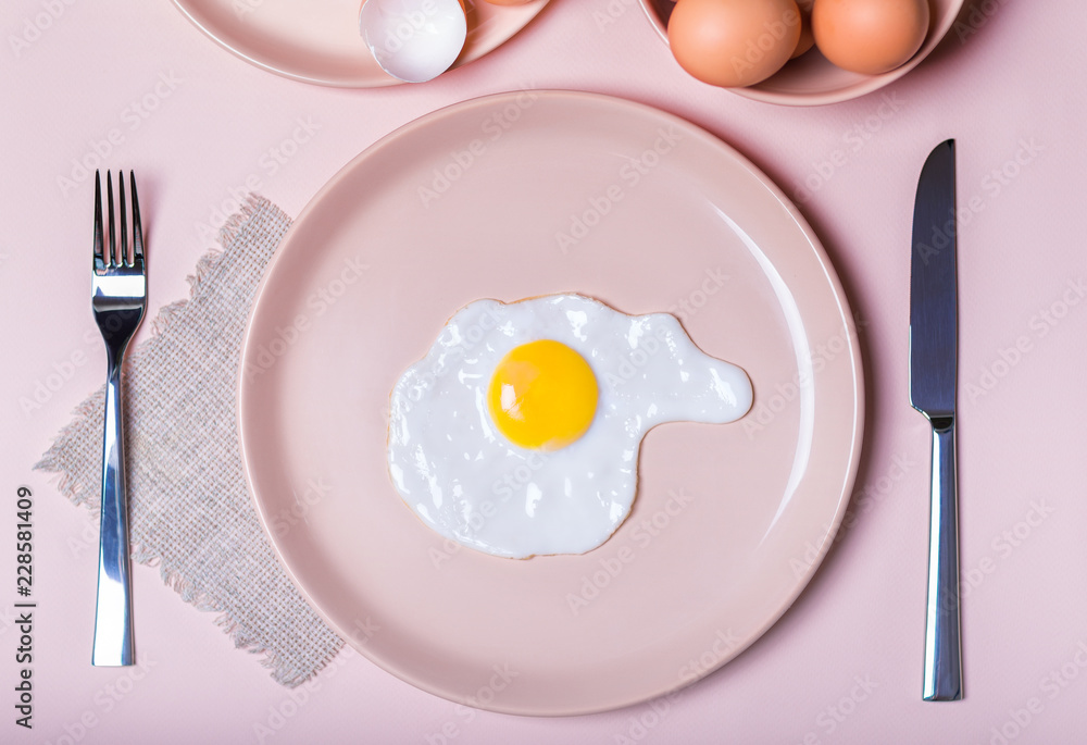 Scrambled eggs on a beige plate. Nearby lie on the table fork and knife. simple breakfast Scrambled eggs on a beige plate. Nearby lie on the table fork and knife. simple breakfast
