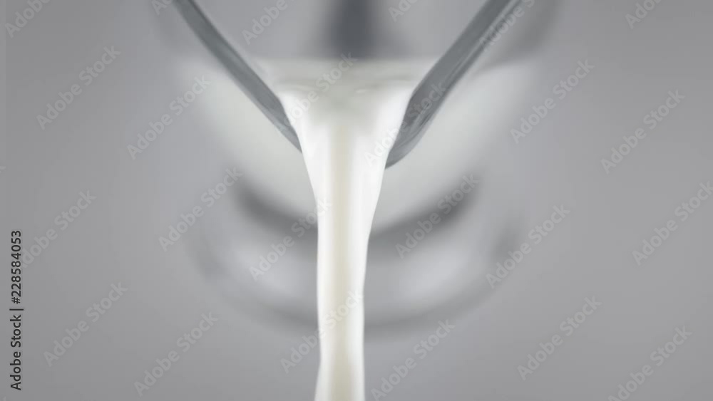 Milk pouring from glass jar in slow motion Milk pouring from glass jar in slow motion