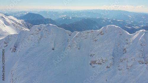AERIAL: Breathtaking view from the air of a mountain range covered in fresh snow