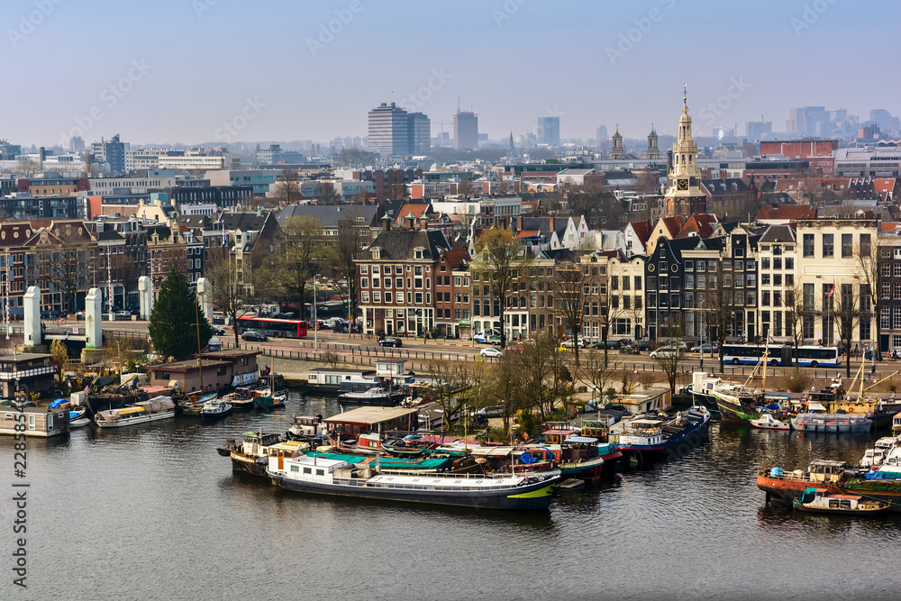 AMSTERDAM, NETHERLANDS - APRIL 10, 2018: Amsterdam skyline cityscape from the Oosterdok in the Netherlands. The Oosterdok is a chanel in Amsterdam .