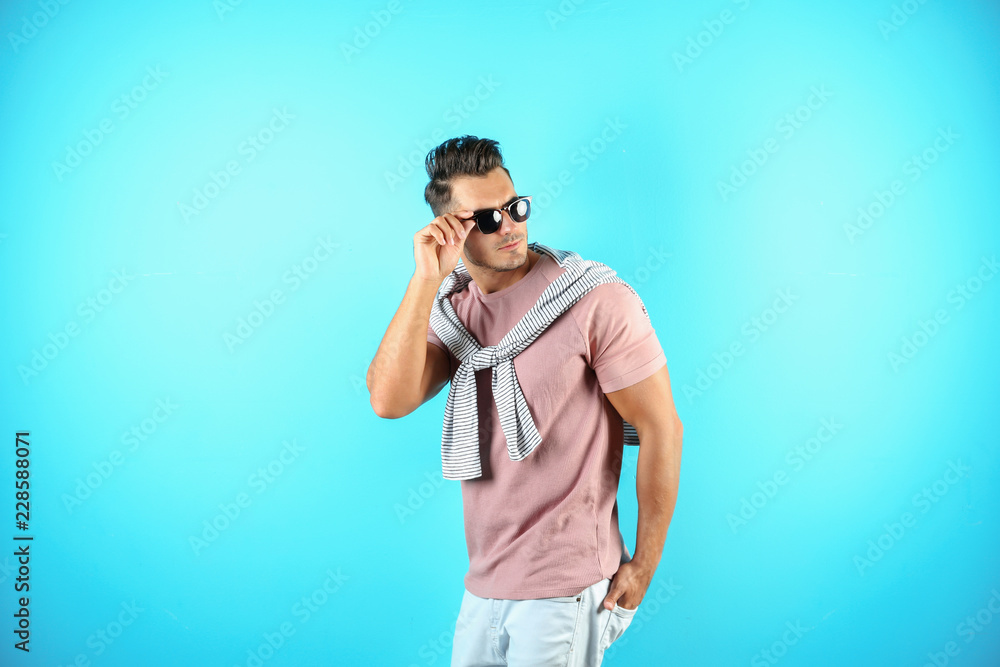 Young man in stylish jeans on color background Young man in stylish jeans on color background