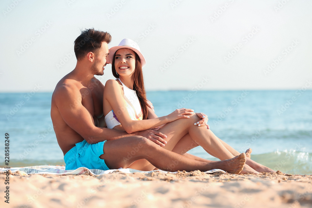 Happy young couple at beach on sunny day