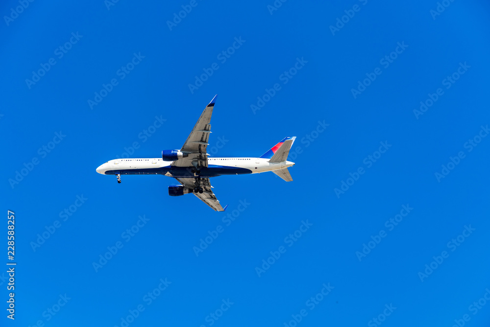 View of the plane against the blue sky, Hawaii, USA. Isolated on blue background. Copy space for text. View of the plane against the blue sky, Hawaii, USA. Isolated on blue background. Copy space for text.