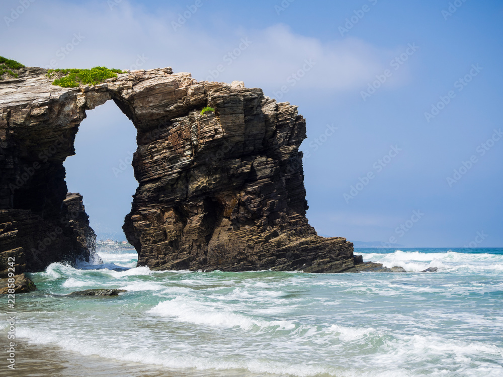 Entorno natural de La Playa de Las Catedrales con arcos de piedra sobre la arena, en Lugo, Galicia, vacaciones en España, verano de 2018
