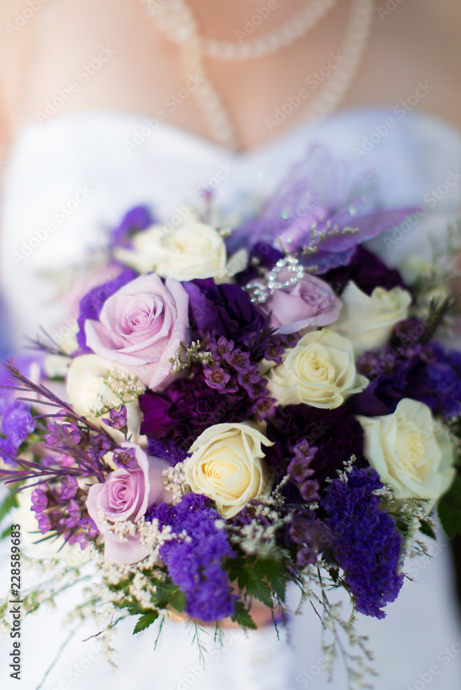 Bride holding bouquet of purple flowers Bride holding bouquet of purple flowers
