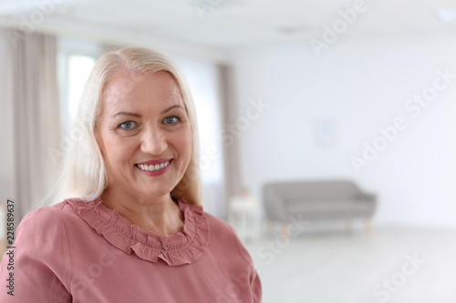 Portrait of beautiful older woman against blurred background with space for text