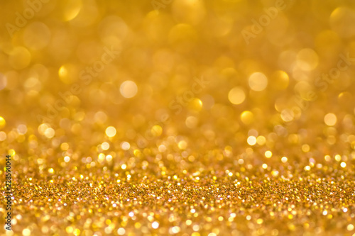 Gold sequins shine bright. Yellow powder. Glitter and bokeh lights. Shining background