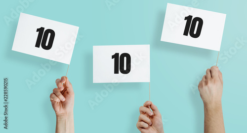 Obraz na plátne Hands hold placards with high marks 10