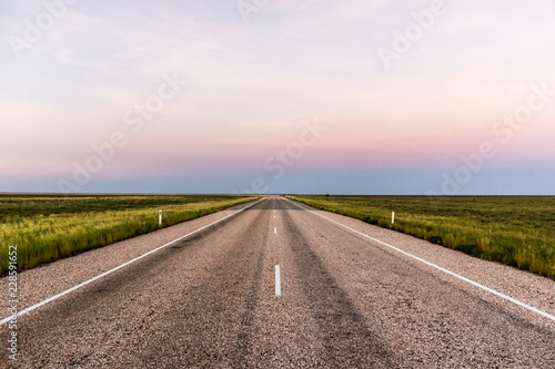 straight road through the outback of Australia, after a beautiful sunset