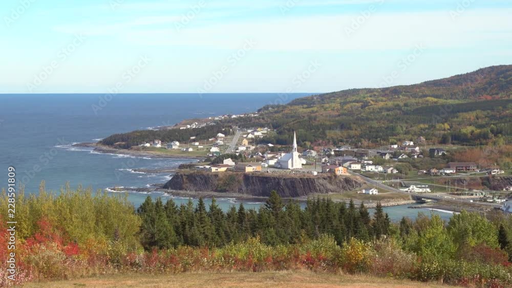 Panning of aerial cityscape, skyline view of Grande-Vallee village town and Saint Lawrence river gulf during day in Gaspe Peninsula, Quebec, Canada, Gaspesie region Panning of aerial cityscape, skyline view of Grande-Vallee village town and Saint Lawrence river gulf during day in Gaspe Peninsula, Quebec, Canada, Gaspesie region