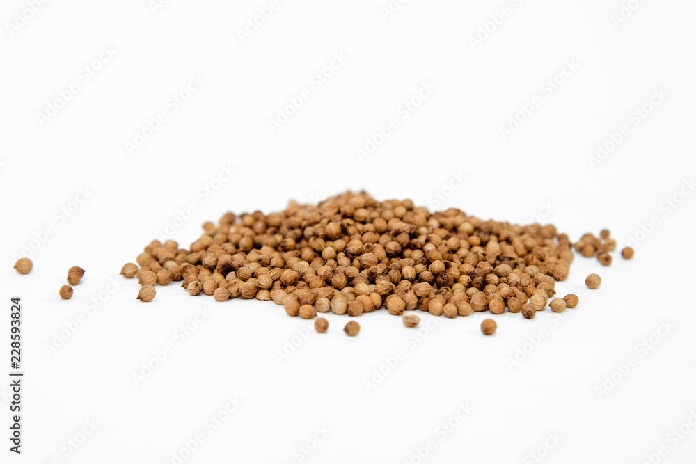Dried coriander seeds. Coriander spilled on a white background. The concept of using herbs and spices for dishes. Strong taste of dishes. Improving the taste. Dried coriander seeds. Coriander spilled on a white background. The concept of using herbs and spices for dishes. Strong taste of dishes. Improving the taste.