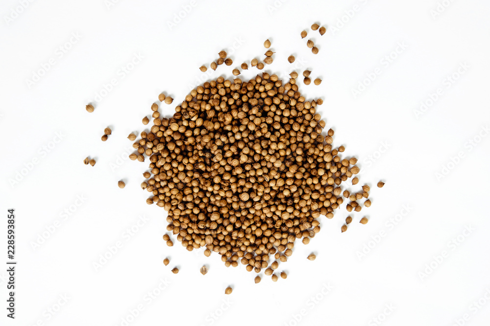 Dried coriander seeds. Coriander spilled on a white background. The concept of using herbs and spices for dishes. Strong taste of dishes. Improving the taste. Dried coriander seeds. Coriander spilled on a white background. The concept of using herbs and spices for dishes. Strong taste of dishes. Improving the taste.