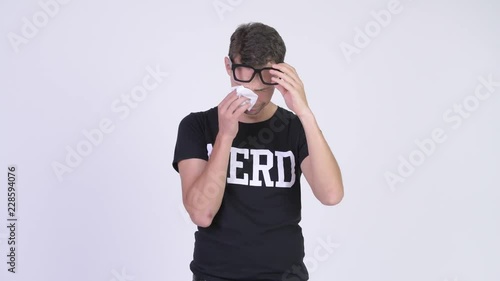 Studio shot of sad nerd man crying