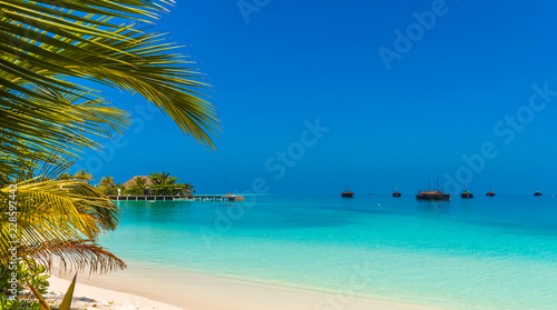 Turquoise ocean with Dhoni boats and a sandy beach  Maldives. Copy space for text.