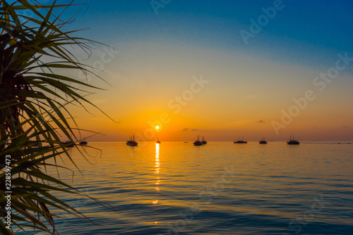 Fototapeta Naklejka Na Ścianę i Meble -  Dhoni boats on sunset background, Maldives. Copy space for text.