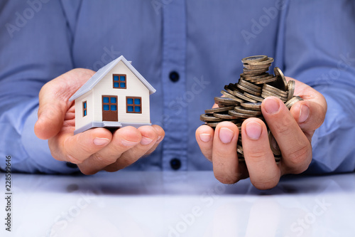Man Holding House Model And Coins