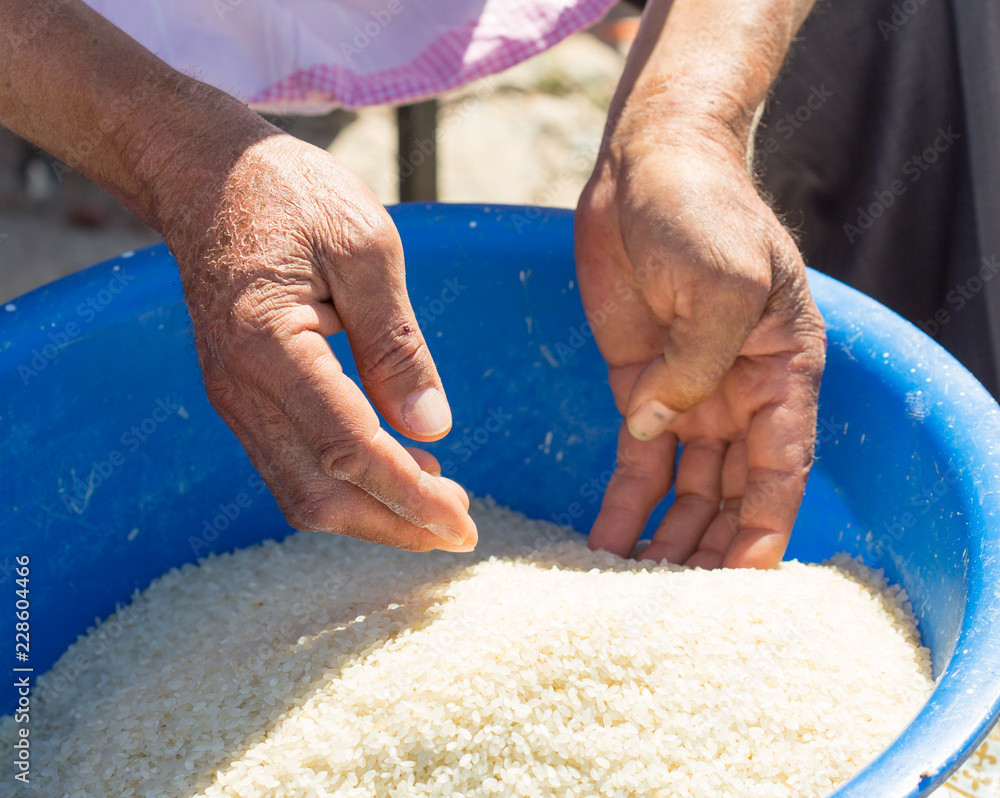 Fototapeta premium man cleans rice for pilaf