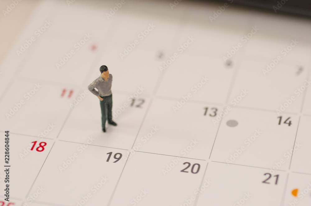 Selective focus miniature people standing planning to do something for the day in middle month