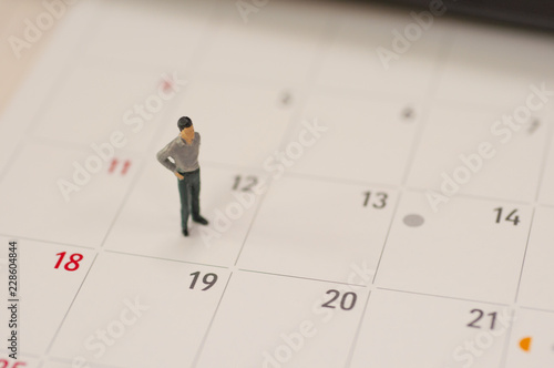 Selective focus miniature people standing planning to do something for the day in middle month